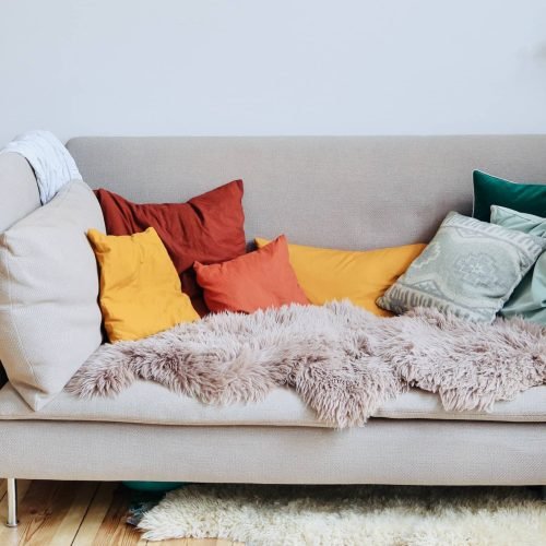 Light coloured sofa with cushions on it